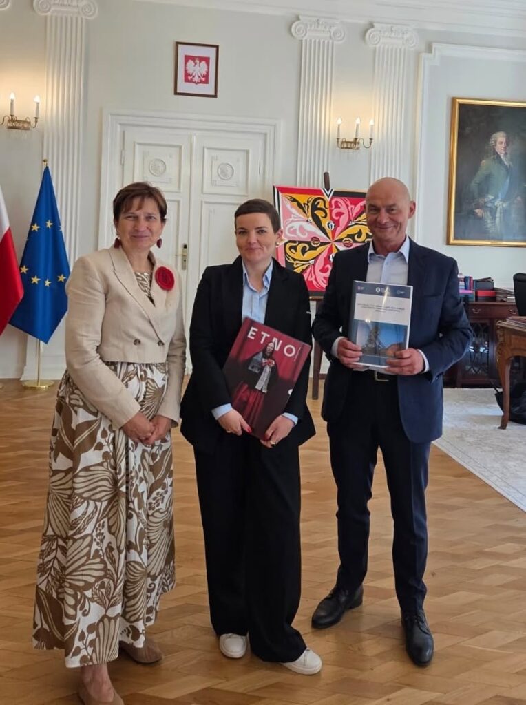 Od lewej stoją: pani Halina Bieda, senator RP, pani Marta Cienkowska, Minister Kultury i Dziedzictwa Narodowego i Bartłomiej Szewczyk, dyrektor Muzeum. Stojący pozują po złożeniu w Ministerstwie wniosku o wpis na listę UNESCO